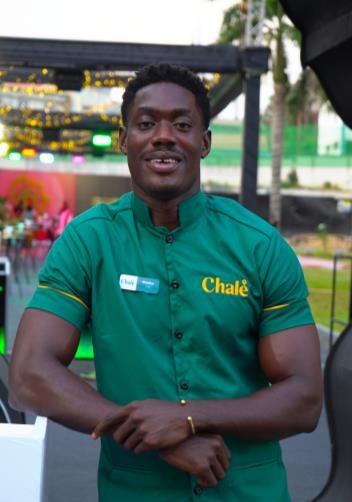 Chalé App crew member smiling in a green uniform shirt